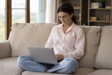 Ciddi öğrenci araştırma yapıyor, dizüstü bilgisayar kullanıyor, online ders izliyor, Webinar giyiyor, kompozisyon yazıyor. Odaklanmış serbest çalışan evden çalışıyor, internette geziniyor.