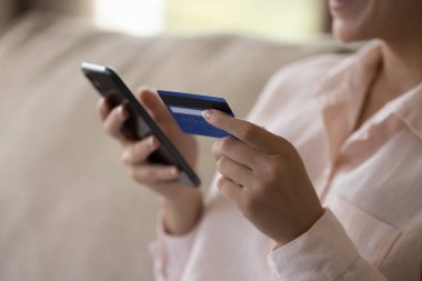 Müşteri, alışveriş yapan kadın sanal satın alma için para harcıyor, cep telefonu, kredi kartı kullanıyor, ekommerce uygulaması ile online alışveriş yapıyor, ödeme yapıyor, internet sitelerinden alışveriş yapıyor. Eller yukarı.