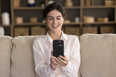 Mutlu cep telefonu kullanıcısı evde video görüşmesinde konuşuyor, gülüyor, selfie çekiyor, ekranda gülümsüyor, cep telefonu web kamerası kullanıyor. Blogger kayıt görüntüleri. İletişim konsepti