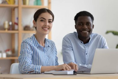 Ofis eğitim merkezinde çalışan çeşitli şirket akıl hocaları ve Afrikalı stajyer kameraya bakıp gülümsüyor. İş arkadaşları, iki çalışan, öğrenci ve öğretmen portresi.