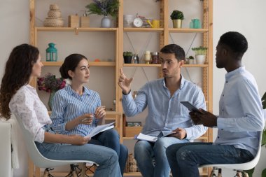 Ofisteki çok ırklı iş ekibiniz iş fikirlerini tartışıyor, proje üzerinde görüşüyor, not defterleri ve cihazlar kullanıyor. Bir grup stajyer ve koç antrenman toplantısında konuşuyor.