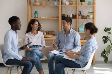 Pozitif çok ırklı bağımlılar daire içinde oturmuş grup terapisi toplantılarında konuşuyorlar, bağımlılık, zihinsel sağlık sorunları, hayat hikayelerini paylaşıyorlar, destek veriyorlar, şefkat gösteriyorlar, gülüyorlar.