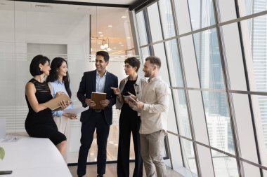 Pozitif meslektaşlardan oluşan çok ırklı iş adamları toplantı odasında bir arada duruyorlar, konuşuyorlar, gülüyorlar, takım çalışması stratejilerini tartışıyorlar, iletişimden keyif alıyorlar, kurumsal ağ kuruyorlar.