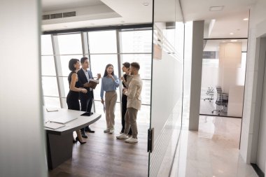 Çeşitli iş arkadaşları ofis toplantı odasında cam duvarın arkasında duruyorlar, konuşuyorlar, proje tartışıyorlar, beyin fırtınası yapıyorlar, takım çalışmasından keyif alıyorlar. Kopyalama alanı ile tam uzunlukta çekim