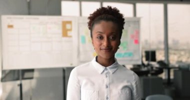 Çekici Afrikalı genç iş kadınının portresi ya da bölüm şefi gülümsemesi iş yerinde poz veren kameraya bakın. İş liderliği, profesyonel çalışan profili, kariyer ve ilerleme