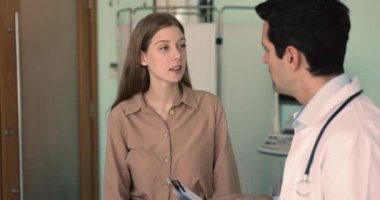 Doktor ve hasta tedavi seçeneklerini, mevcut semptomları, olası faydaları ve riskleri, beklenen teşhisi tartışırlar. Kadın müşteri profesyonel yardım alıyor, teşekkür ediyor, el sıkışıyor ve randevusunu bitiriyor.