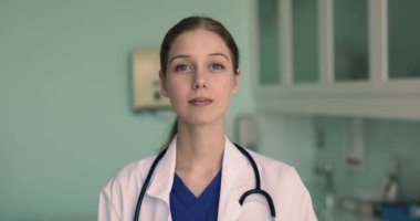 Profesyonel pratisyen hekimin mutlu fotoğrafı, iş yerinde poz veren kadın kardiyolog, kameraya bakıyor, iş sonuçlarından, görevden ve meslekten memnun. Sağlık sigortası, sağlık çalışanı portresi.