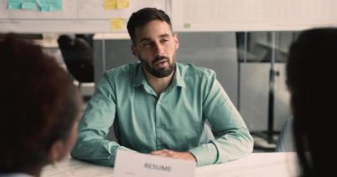 Mutlu İspanyol erkek başvuru sahibi HR yöneticileriyle tokalaşıyor, iş görüşmesini ofiste bitiriyor, saygı gösteriyor, başarıdan ve kariyer fırsatından tatmin oluyor, işe alınıyor. Kariyer, insan kaynakları