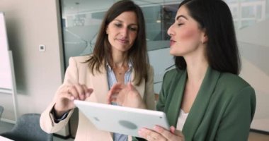 Modern dijital tablet kullanılarak ortak bir online proje veya ortak görev üzerinde çalışan iki çok ırklı iş arkadaşı, el sıkışarak, görevdeki başarılı ve etkili takım çalışmalarına duydukları saygıyı dile getirdiler. İş dünyası