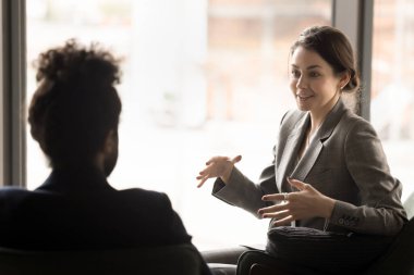 Resmi ceketli mutlu, nişanlı genç bir iş kadını. Ortağıyla konuşuyor, ofis molasında, koltukta oturuyor, konuşuyor, el kol hareketi yapıyor, gülüyor, projeyi tartışıyor.