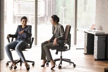 Mutlu, çoklu etnik çeşitlilikte yöneticileri heyecanlandıran kadınlar yüksek sesle gülüyor, ofis koltuklarında oturuyor, konuşuyorlar. Şirket çalışanları, proje arkadaşları başarıyı kutluyor, birlikte eğleniyorlar.