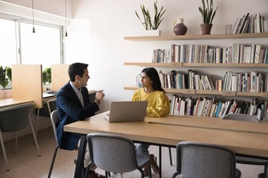 Ciddi çok ırklı patron ve yönetici proje stratejisini tartışıyor, ofis çalışma odasında takım çalışması, büyük masada toplantı, sohbet. Kütüphanede erkek eğitmen kız öğrenci.