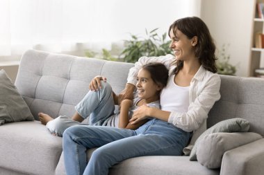 Annemle birlikte rüya görüyorduk. Mutlu, genç bir kadın, koruyucu anneyi önemsiyor. Kanepede gülümseyen liseli bir kızla oturuyor. Evlat edinilen kız çocuğu sevgiyle kucaklıyor ve geleceğe dair hayallerini paylaşıyor.