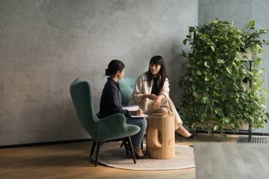 Ofis salonunda konuşan, koltukta oturan çeşitli iş kadınlarıyla meşgul. Hintli profesyonel mülakat meslektaşı, notlar yazıyor. Yetişkin akıl hocası stajyer öğretmen. Tam boy çekim