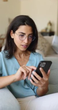 SMS 'te mutlu haberler, iyi bir teklif, online piyango kazanma ve başarılar. Dikey görünümlü çekici Brezilyalı kadın modern akıllı telefon kullanıyor, banka tebligatını okuyor, harika haberi mesajla kutluyor