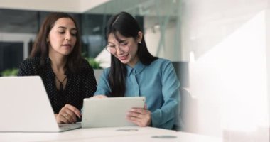 Modern dijital tablet ile ilgili iş birliği yapan iki kadın meslektaşı, belgelerin incelenmesi, verilere erişim, bilgi veya fikirlerin paylaşımı, satış sonuçlarının analiz edilmesi, proje ayrıntılarının tartışılması