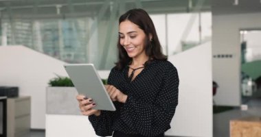 Milenyum Arap iş kadını, modern çalışma alanında tek başına duran tablet cihazını kullanıyor, internette sohbet ediyor, görev veya sunum hazırlıyor, kurumsal e-postalar, teknoloji ve internet kullanarak iş akışı üzerine cevaplar veriyor.