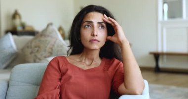 Genç Latin bir kadın kötü haberden dolayı hayal kırıklığına uğruyor, sıkıntılı bir durumla karşı karşıya kalıyor, düşünüyor, evde tek başına oturuyor, stres ya da endişe yaşıyor, zorluklarla yüzleşiyor, hayat zorluklarını yansıtıyor.