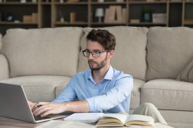 Evde okuyan, dizüstü bilgisayarda yazan, makale yazan, makale yazan, araştırma yapan, öğrenim kitaplarını, açık kitapları, eğitim için internet teknolojisini kullanan ciddi bir yetişkin öğrenci.