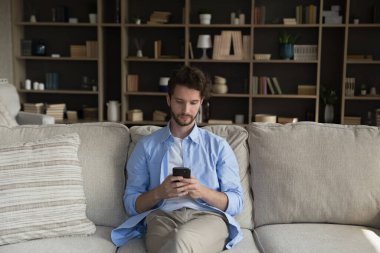 Ciddi genç akıllı telefon kullanıcısı mesaj atıyor, sohbet ediyor, daktilo ediyor, ekommerce uygulamasını online alışveriş, sanal servis, yazılım, internet üzerinden ödeme yapmak için kullanıyor