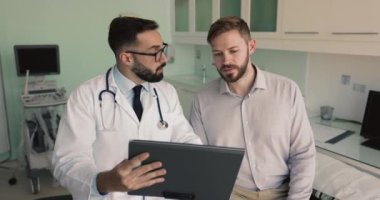 Hasta röntgen sonuçlarına, tedavi planına, ilaç listelerine bakan erkek doktor. Profesyonel tıbbi bakım almak için kliniğe giden adam, pratisyen hekimle konuştu, sağlık tavsiyesi aldı ve tahminler