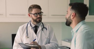 Beyaz üniformalı bin yıllık profesyonel doktor hastalarla konuşur, sağlık şikayetlerini dinler, sağlık kartına not alır. Özel klinikte düzenli sağlık kontrolü. İlaç.