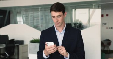 Akıllı telefon kullanan genç işadamı, uzaktan işle ilgili meseleleri çözüyor, iş arkadaşınızla bilgi paylaşıyor, bilgilendirmeyi okuyor, kontrol organizatörünü kontrol ediyor, planlamacıyı dolduruyor, program uygulamasında toplantı düzenliyor