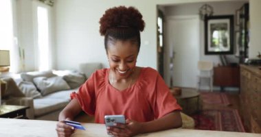 Neşeli Afrikalı kadınlar evlerinde elektronik alışveriş yapmaktan, kart ve akıllı telefon üretiminde çalışmaktan, e-servis ve hediyeler almaktan, satın almaktan ve güvenli e-ödemelerden memnun olurlar.