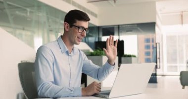 Video bağlantısı olan bir adam, masada oturuyor, yardım sağlıyor, danışmanlık yapıyor, iş ortağıyla laptopta iletişim kuruyor. İş videosu etkinliği, sanal toplantı, kurumsal istemciyle profesyonel etkileşim