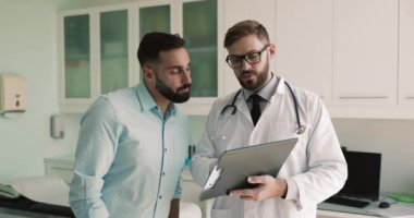 Sağlık testi sonuçlarını gösteren pratisyen hekim, tedavi planını açıklayan, konsültasyonu bitiren, hastayla el sıkışan, profesyonel tıbbi bakım, yararlı bilgi ve yardım için saygı ve minnettarlığını ifade eden adam.