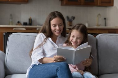 Pozitif dadı, bebek bakıcısı ve evde kitap okuyan, kanepede oturan anaokulu çocuğu. Genç anne çocuğa edebiyat öğretiyor, kıza çalışmasında yardım ediyor, ev ödevi yapıyor, peri masalı anlatıyor.