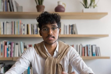 Ciddi derecede zeki Hintli öğrenci ekrandan online konferans sohbetine, sosyal medyada yayına, halk kütüphanesinden internete, Webinar 'a, kameraya bakıyor. Kafasından vurulmuş.