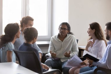 Hintli adam grup terapisi hakkında konuşuyor, hikayeyi paylaşıyor, problem var. İşletme ekibi daireler çizerek oturuyor, konuşuyor, çözümleri tartışıyor, proje fikirleri, beyin fırtınası...