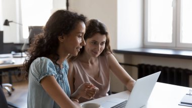 İki farklı çalışan proje görevleri üzerinde birlikte çalışıyorlar, laptopu paylaşıyorlar, online sunum izliyorlar, video görüşmeleri yapıyorlar. Şirket öğretmeni stajyeri. İş iletişimi kavramı