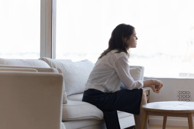 Üzgün, yalnız, genç bir kadın evdeki kanepede oturuyor, derin şok düşünceleriyle pencereye bakıyor, kayıpla, kederle, başarısızlıkla, kötü haberlerle, travmayla, kürtajla, kısırlıkla başa çıkıyor.
