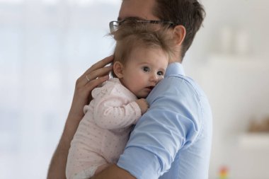 Mutlu, genç bir baba kucağında masum bir bebek, kucağında sevgi, özen ve şefkatle küçük bir çocuğa sarılıyor. Sevimli bir çocuk babasının omzunun üzerinden başka tarafa bakıyor. Babalık, çocuk bakımı, aile kavramı