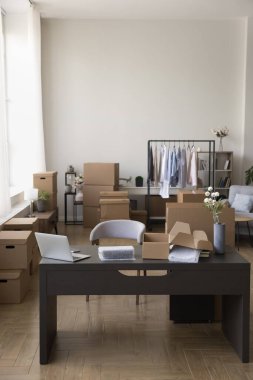 Perakende internet mağazasında boş bir işyeri ya da yönetici danışman çalışma masası ile çevrimiçi pazarda, paket karton kutularla dolu depo ve dizüstü bilgisayarlı müşterilerin siparişlerini teslim etmek için.