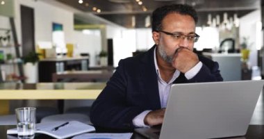 Modern iş ofisinde dizüstü bilgisayarda çalışan orta yaşlı işadamı, e-posta üzerine kafa yoran, şirket müşterilerine e-posta göndererek yazışmalar yapan, yeni kurumsal görevi gözden geçiren, yazılım odaklı görünmeyi öğrenen