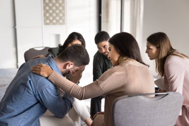 Çeşitli psikolojik sorunları olan genç insanlar grup terapisi için toplanıyor, duygusal destek seansı, çemberde oturuyor, ağlayan umutsuz adama teselli ve sempati veriyor.