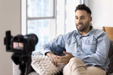 Yakışıklı Latin blogcu, refleks kamerayla kendini videoya çekiyor, blog, vlog, sosyal medya, konuşma, gülümseme, eğitim, konferans, webinar için içerik oluşturuyor.