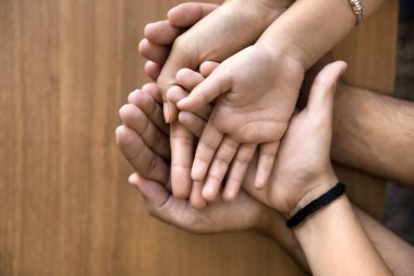 Ailelerin ve çocukların avuçlarını açık bırakmışlar. Baba, anne ve çocukların elini tutuyor. Aile destek, güvenlik, dostluk, sigorta, ev satın alma, ipotek jestleri yapıyor