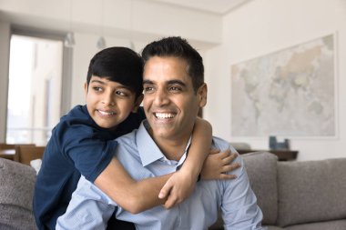 Mutlu 40 'lı yıllar Hintli baba ve neşeli hayalperest çocuk birlikte kanepede oturuyor, sarılıyor, başka tarafa bakıyor, gülümsüyor, düşünüyor, ailecek zaman geçiriyorlar. Ergen oğul babaları kucaklıyor.