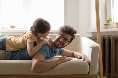 Aile oyun zamanını ve evde konuşmayı sever, baba güzel kızına sevgiyle bakar, çocuk babasının sırtına yaslanır sohbet eder, evde kaygısızca vakit geçirir. Mutlu babalar, boş vakitler.