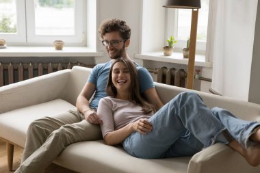 Güzel, genç bir çift, oturma odasındaki rahat kanepede birlikte gülüyor, sohbetin tadını çıkarıyor, şakalaşıyor, evde güzel bir hafta sonu uykusu çekiyorlar. İlişkiler, iletişim, aşk