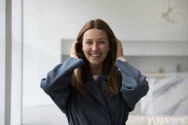 Neşeli, güzel, 30 'lu yılların beyaz kadın portresi. Havalı palto, siper, palto giymiş güzel bir bayan dişlek gülümsemeli kameraya bakıyor, gülüyor, uzun saçlarını düzeltiyor. Moda.