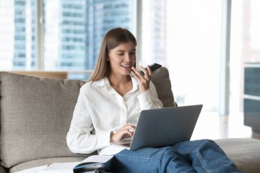 Kendine güveni tam bir serbest çalışan kadın. Evdeki kanepede aletlerle dinleniyor, bilgisayardaki hoparlörden konuşuyor iş iletişimi için internet uygulaması kullanıyor, sesli mesaj kaydediyor.