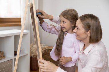 Sevgi dolu bir anne, neşeli kızına küçük tahta üzerinde resim çizmeyi öğretiyor, tebeşirle çocukları tutuyor, yumurtadan çıkmalarına yardım ediyor. Annelik, günlük bakım, eğitim kavramı