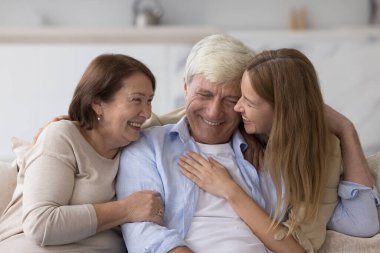 Neşeli yetişkin kadın yaşlı ebeveynlere sarılıyor, gülümsüyor, gülüyor, anne ve babamla sohbet ediyor, eğleniyor, ilişki yaşıyor, şefkat, ilgi gösteriyor. Aile babalar gününü kutluyor
