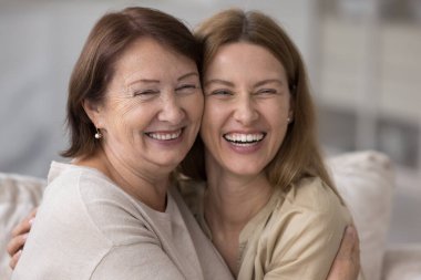 Mutlu büyük anne, güzel yetişkin kızı kucaklıyor, neşe, şefkat, gülümseme, birlikte şakalara gülme, rahatlık, destek, ilgi, ebeveynlik, annelik, annelik.