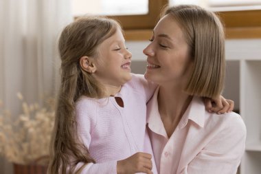 Güzel, genç bir anne ve küçük tatlı bir kız birbirlerine sarılıyorlar neşeli görünüyorlar, sevgi dolular, koşulsuz sevgi evde birlikte vakit geçiriyorlar. Aile bağı, mutlu annelik kavramı